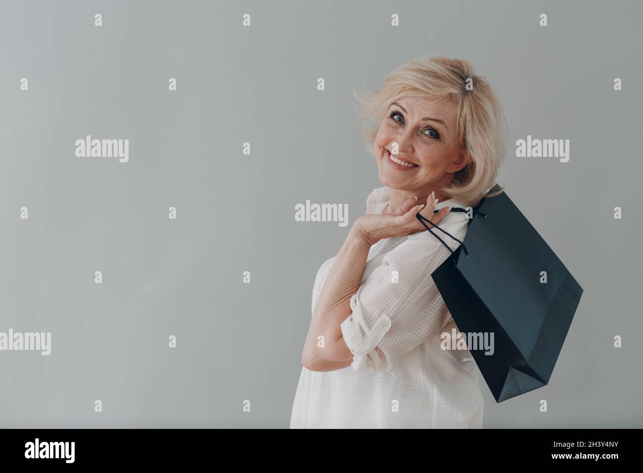 Ältere kaukasische alte Frau Porträt grauhaarige Porträt mit Einkaufstaschen. Stockfoto