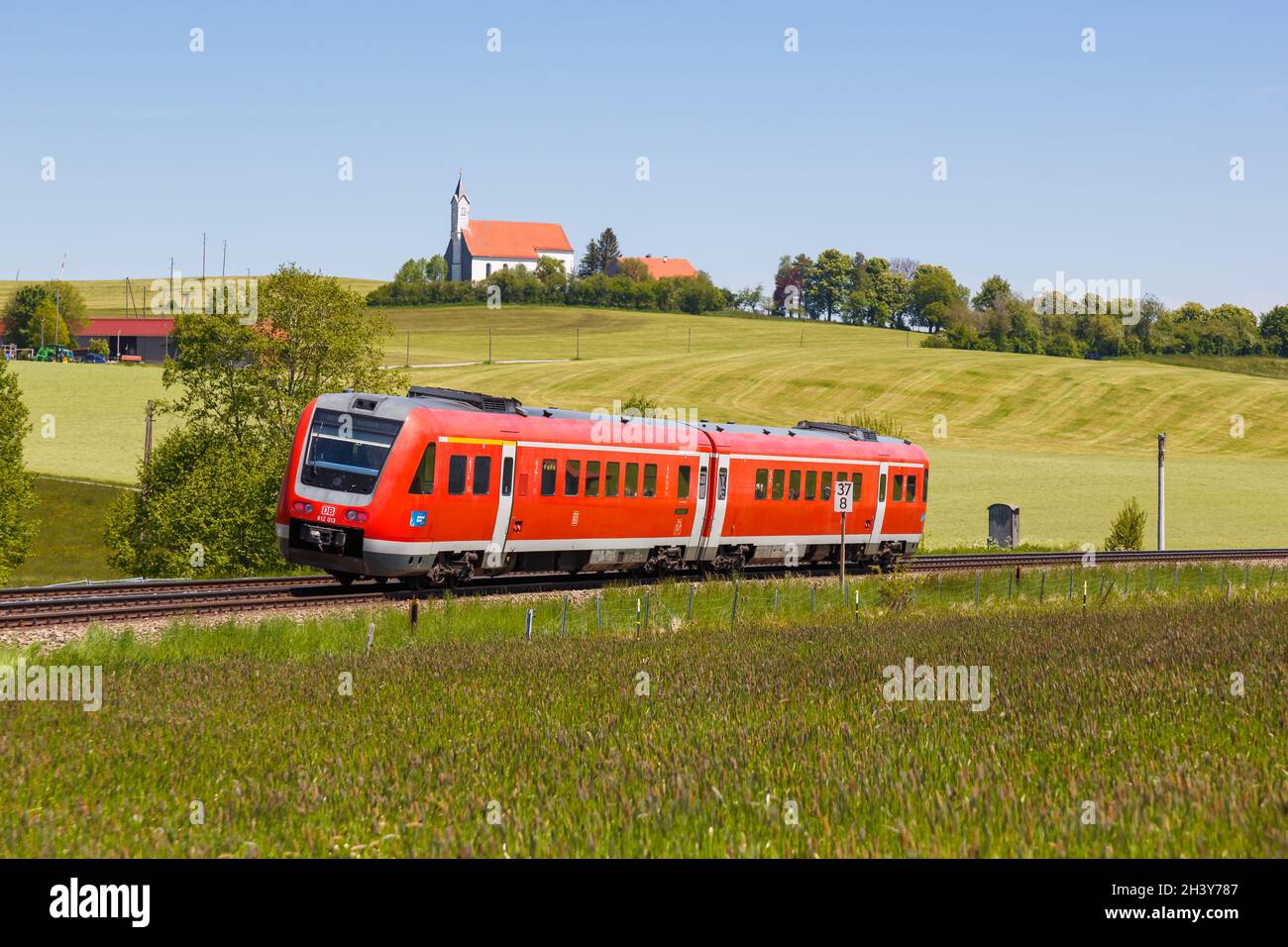Bombardier Transportation RegioSwinger Kipptechnik Regionalzug der Deutschen Bahn DB in Aitrang Bayern mit Kirche St. Stockfoto