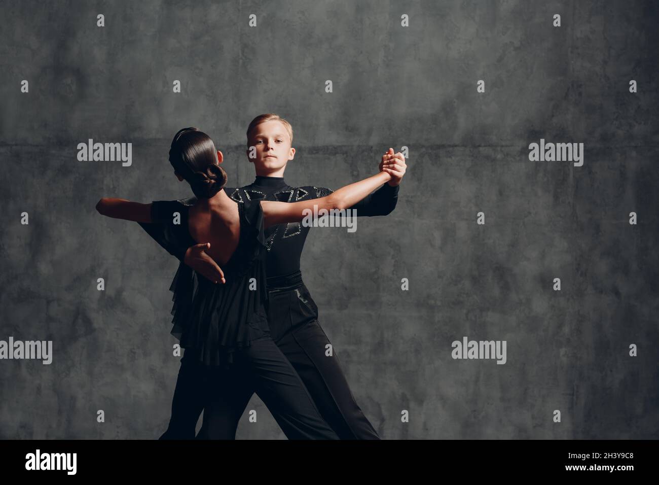 Zwei Tangotänzer in schwarzem Kostüm tanzen im Ballsaal Stockfoto