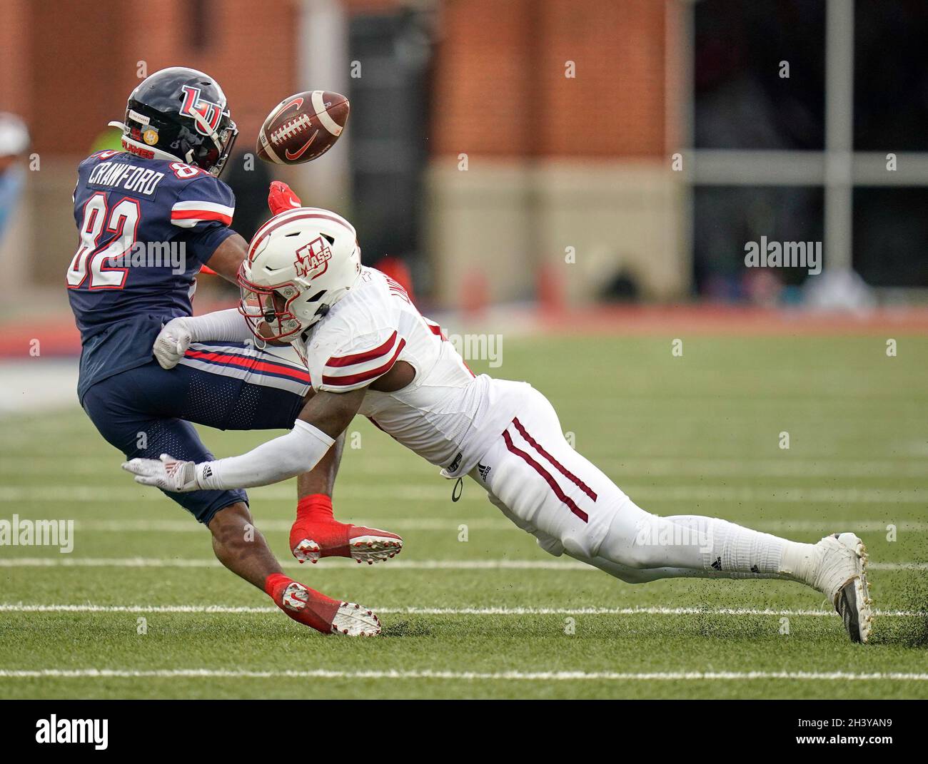 Lynchburg, Virginia, USA. Oktober 2021. Der Eckpfeiler von Massachusetts Minutemen Donte Lindsey (5) bricht während eines College-Fußballspiels zwischen dem Massachusetts Minuteman und den Liberty Flames im Williams Stadium in Lynchburg, Virginia, einen Pass für den Liberty Flames Wide Receiver D'Wayne Crawford (82) auf. Rusty Jones/Cal Sport Media/Alamy Live News Stockfoto