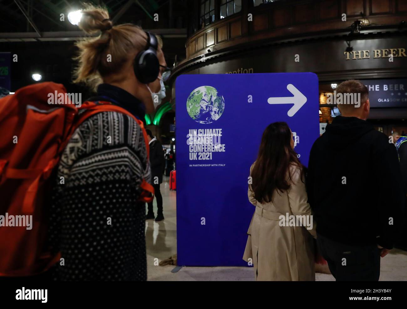 Glasgow, Großbritannien. Oktober 2021. Am 30. Oktober 2021 passieren Menschen am Bahnhof Glasgow Central in Glasgow, Schottland, Großbritannien, ein Schild. Die 26. UN-Klimakonferenz der Vertragsparteien (COP26) ist vom 31. Oktober bis 12. November in Glasgow, Schottland, geplant. Dies ist das erste seiner Art seit Inkrafttreten des Pariser Abkommens. Quelle: Han Yan/Xinhua/Alamy Live News Stockfoto