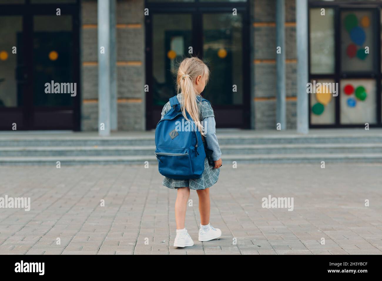 Nettes kleines Mädchen mit Rucksack zu Fuß zurück zur Schule Stockfoto