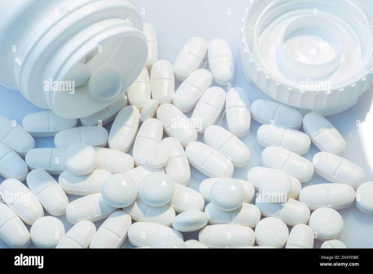 Helsinki / Finnland - 31. OKTOBER 2021: Nahaufnahme von weißen Pillen vor weißem Hintergrund. Weißer Pillenbehälter im Hintergrund. Stockfoto