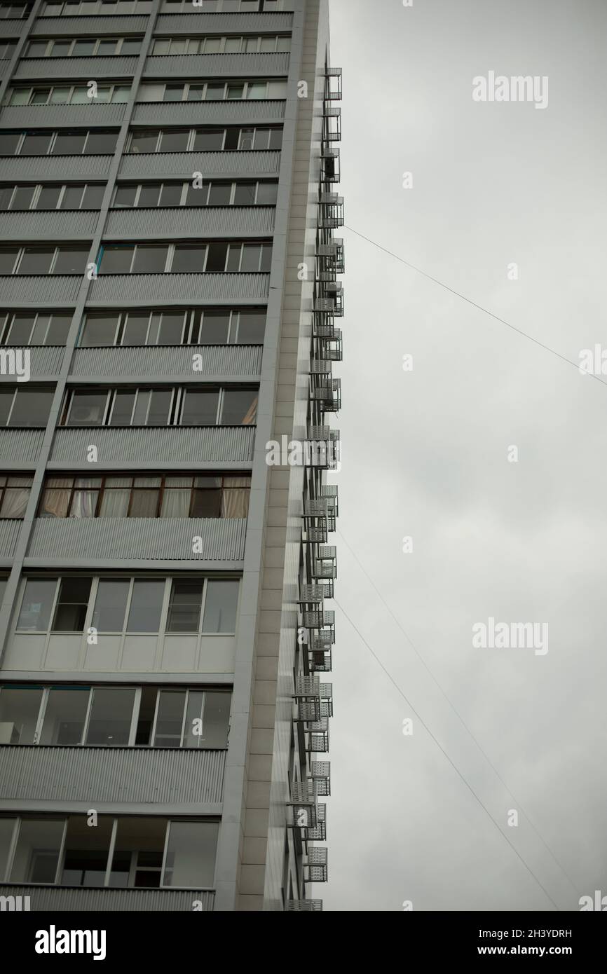 Hohes Gebäude mit Fenstern und Balkonen. Stadtentwicklung im 21. Jahrhundert. Architektur des 20. Jahrhunderts in der Sowjetunion. Haus mit Apar Stockfoto