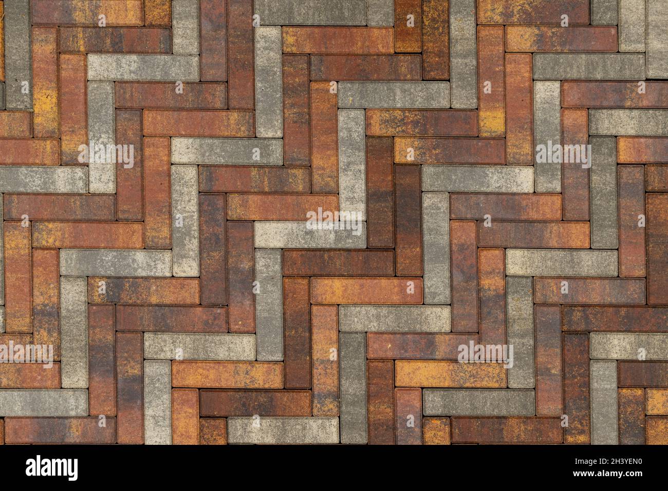 Textur und Vollrahmen Hintergrund aus braunem, gelbem und grauem Parkett Kunststein Bürgersteig Stockfoto