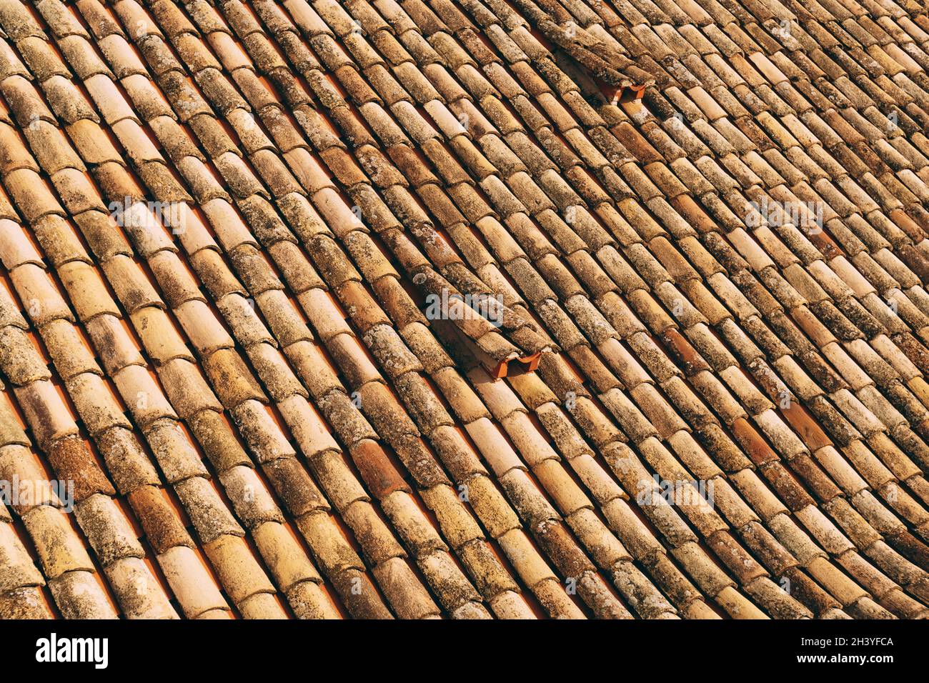 Die Textur der alten braunen Schindeln auf dem Dach des Gebäudes. Stockfoto
