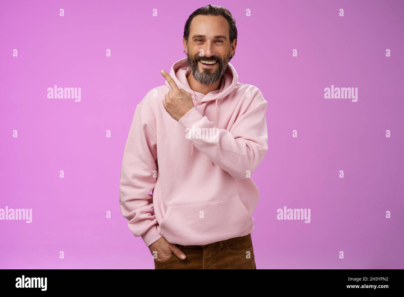 Charmant freundlich glücklich reifen Mann 50s bärtigen grauen Haaren lachen glücklich zeigen obere linke Ecke hinter stolz Famii Stockfoto