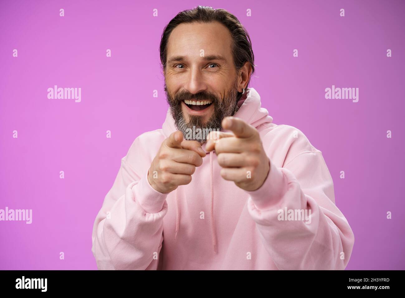 Lustig amüsiert sorglos glücklich Erwachsene schöner Mann prucking Freund Narr um zeigen Kamera Index Finger Gruß Wahl Sie l Stockfoto