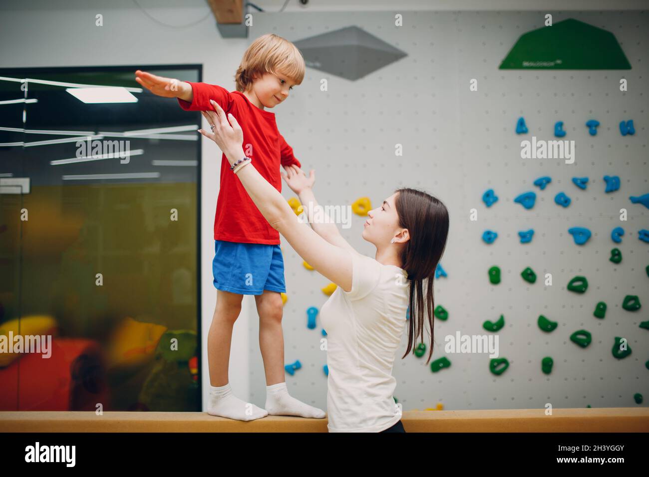 Kinder, die im Kindergarten oder in der Grundschule Gymnastik im Fitnessstudio machen. Sport- und Fitnesskonzept für Kinder. Stockfoto