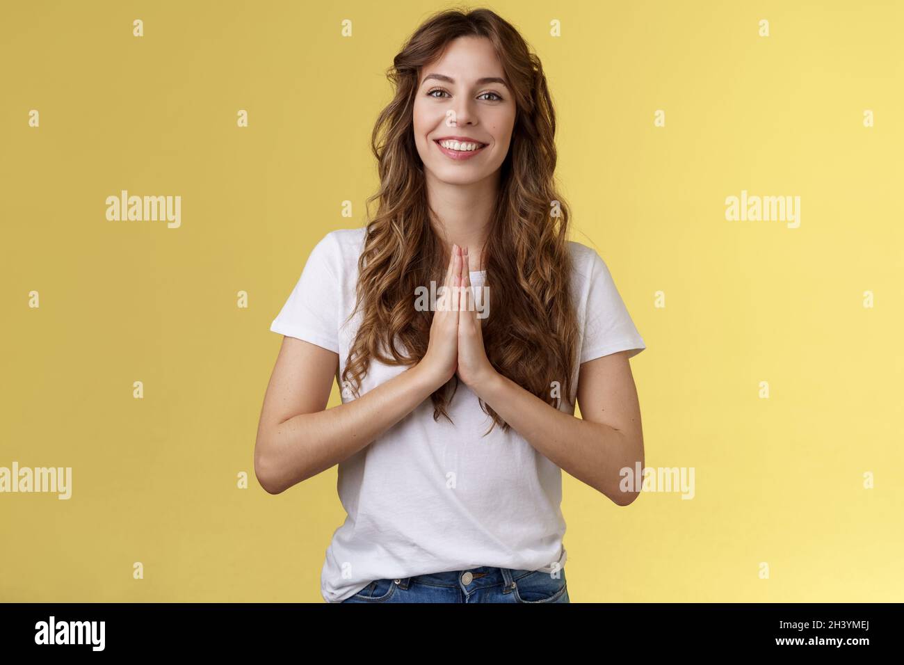 Fröhliche zuversichtlich ausgehende junge höfliche Mädchen sagen namaste Begrüßung asiatische Gäste lächelnd gerne danken für Besuch Hold Hands pra Stockfoto