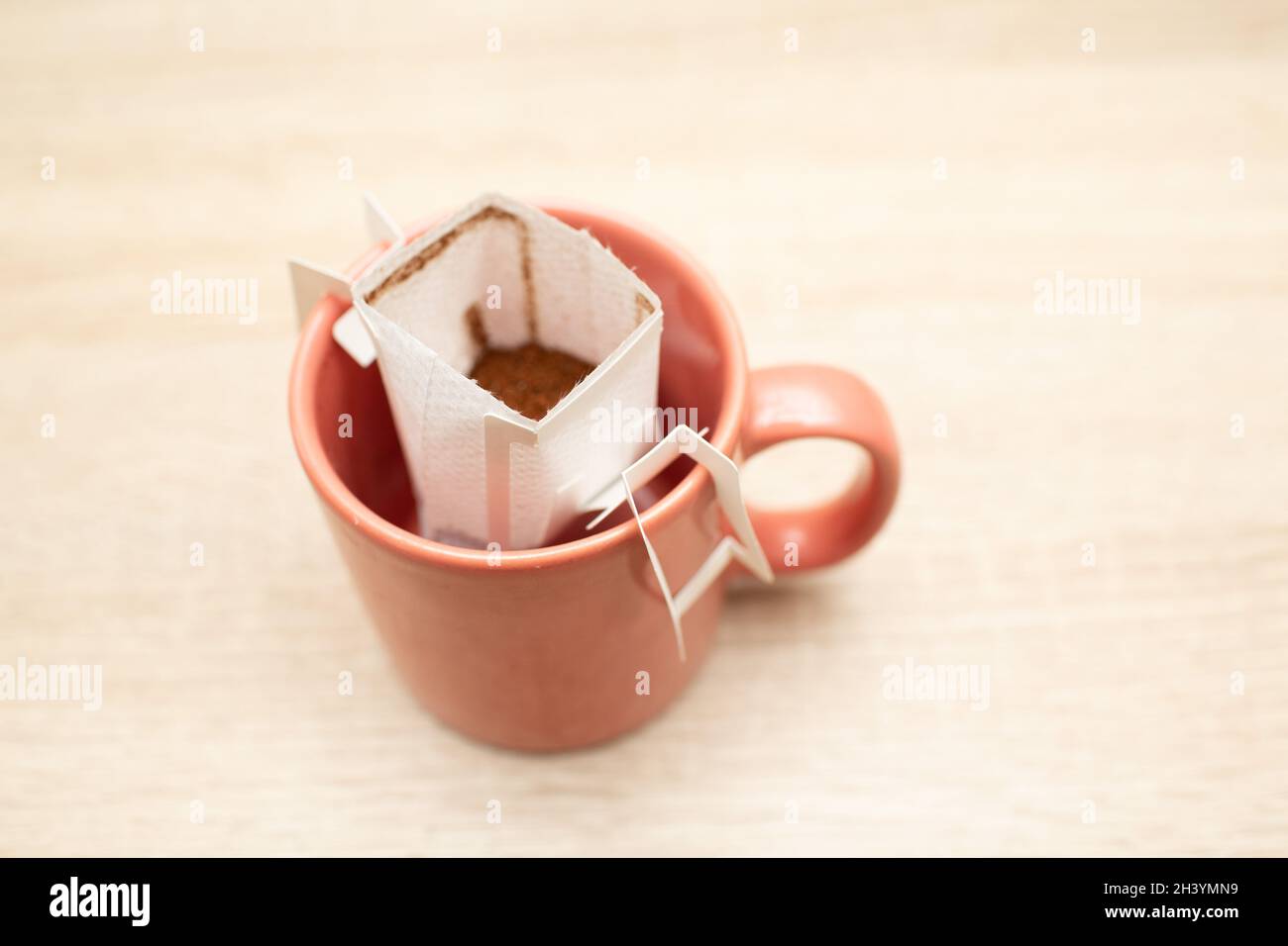 Kaffee tropft in die Tasse. Alternativer Brühkaffee in Papierfiltertüten. Stockfoto