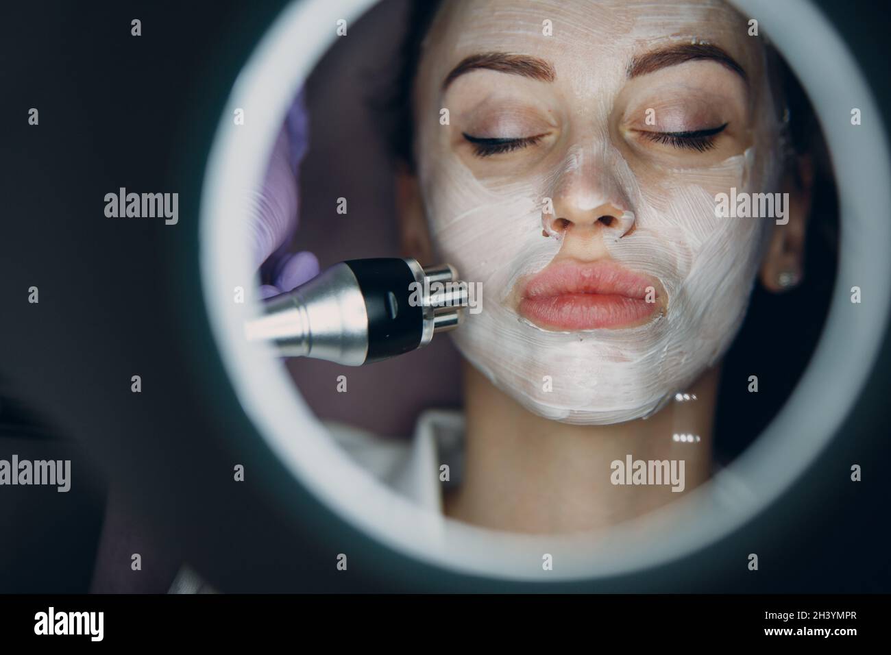 Junge Frau erhält eine elektrische RF-Lifting-Gesichtsmassage im Beauty-Spa mit Elektroporationsgeräten. Stockfoto