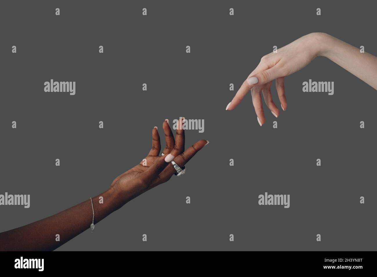 Kaukasische und afroamerikanische Hand, die sich gegenseitig ausstreut Stockfoto