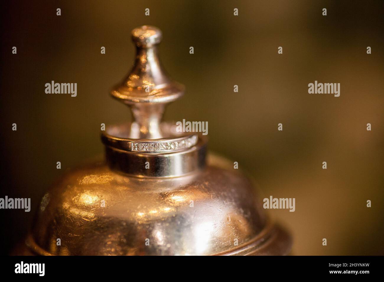 Eheringe Detail auf Metall-Kelch mit Brautstrauß im Hintergrund, Braut und Bräutigam Hochzeit Set, einfache Details Stockfoto