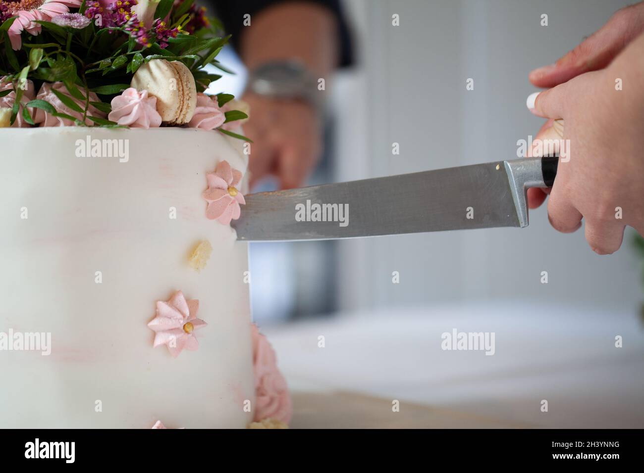 Detail von Braut und Bräutigam schneiden Hochzeitstorte nach der Heirat Stockfoto