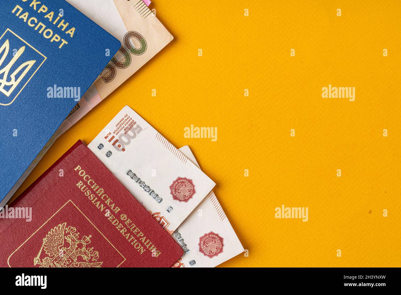 Ukrainischer und russischer Pass mit Geld, russischem Rubel und ukrainischer Griwna Stockfoto