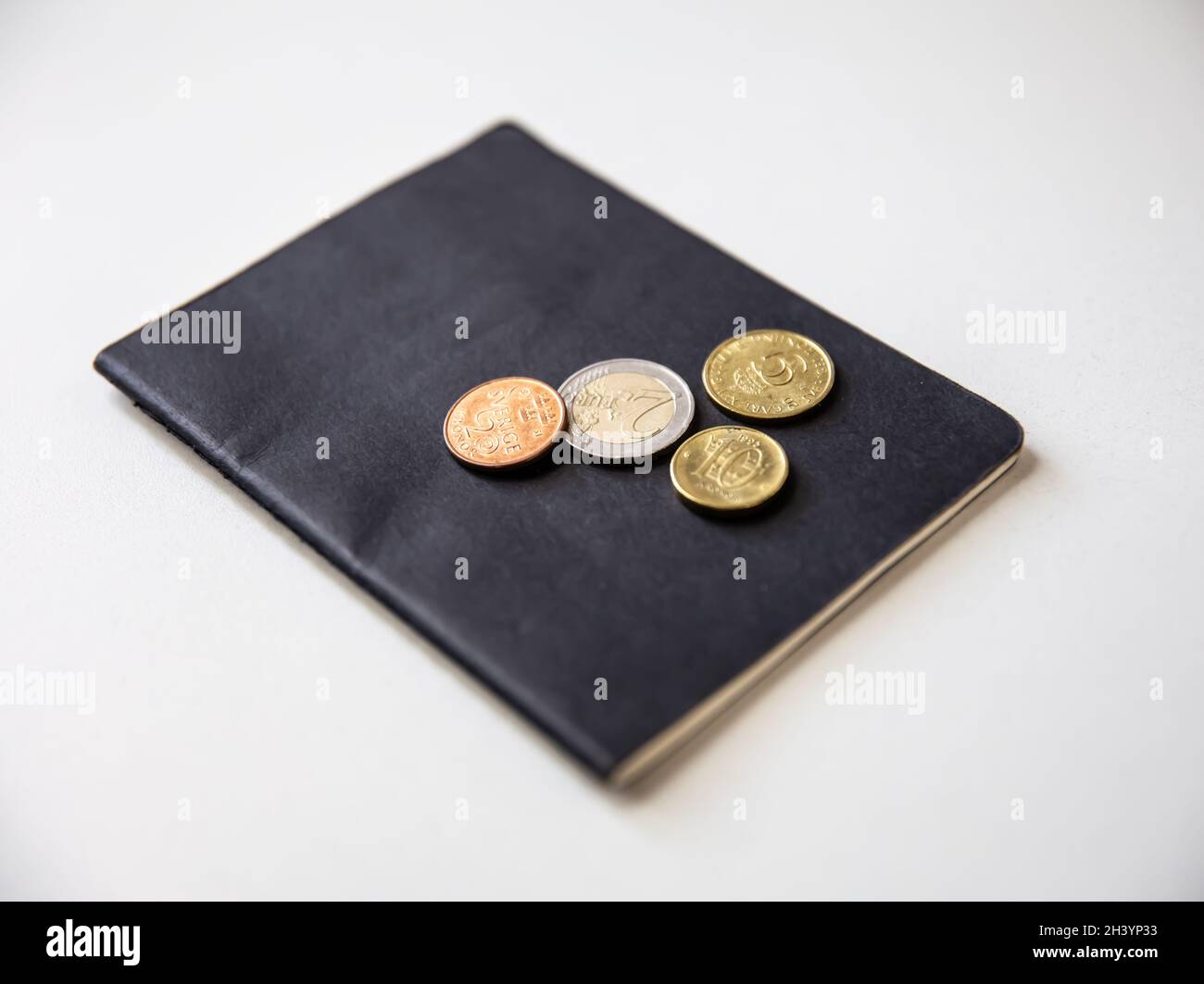 Nahaufnahme von Reisepass und Münzen auf weißem Hintergrund. Stockfoto