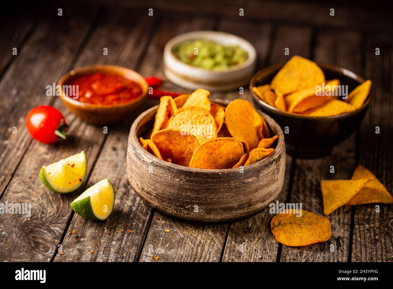 Zwei Biowls gelber Mais Tortilla Nachos Chips mit Salsa Und Guacamole Sauce auf Holzgrund Stockfoto