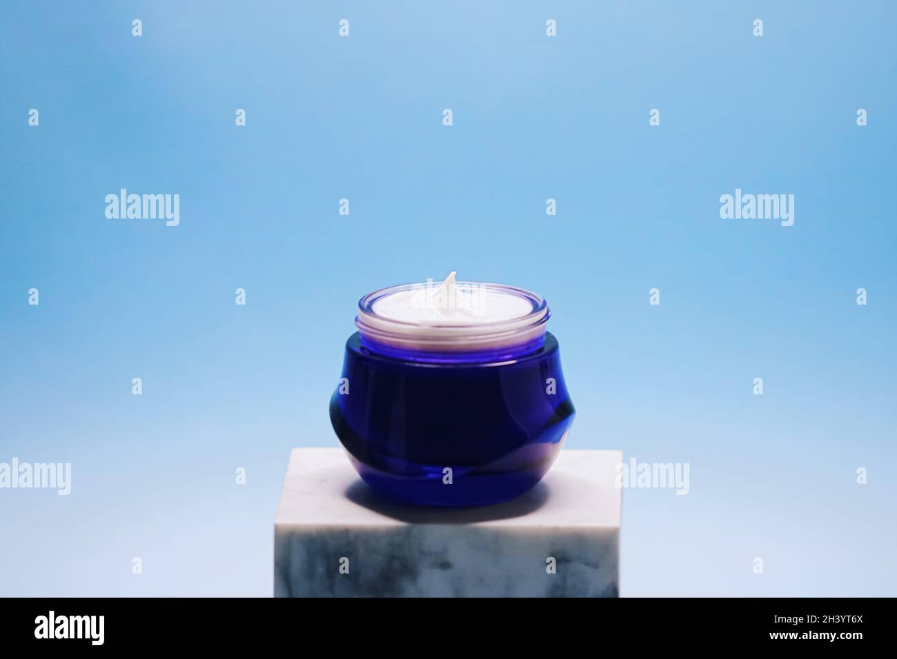 Anti-Aging-Pflege und Kosmetik, Beauty-Gesichtscreme im Glas auf blauem Hintergrund Stockfoto