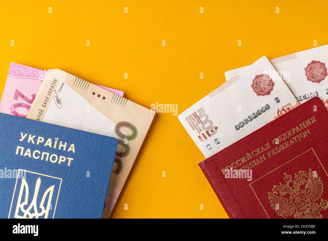 Ukrainischer und russischer Pass mit Geld, russischem Rubel und ukrainischer Griwna Stockfoto