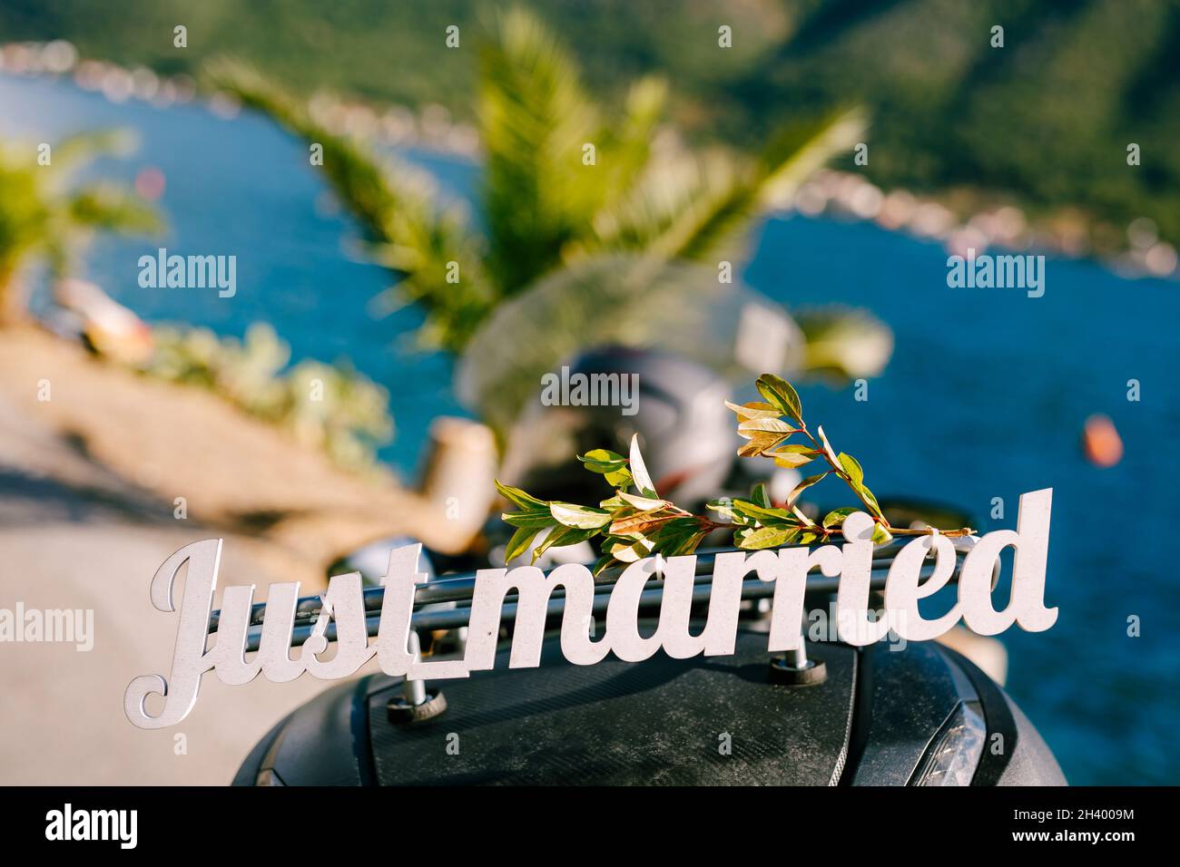 GERADE VERHEIRATET Schriftzug auf Motorrad-Kofferraum. Weiße Holzbuchstaben. Motorrad am Wasser in Perast, Montenegro geparkt. Der Stockfoto