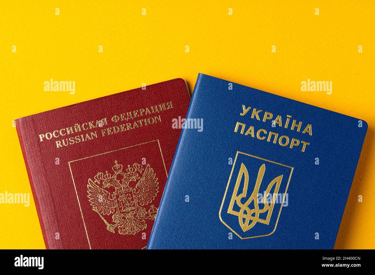Russischer und ukrainischer Pass zusammen auf gelbem Hintergrund Stockfoto