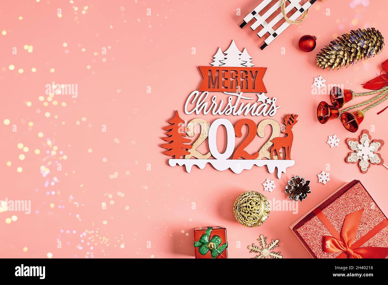 Weihnachtlich rosa Hintergrund mit Geschenkboxen, Dekorationen und Tannenzweigen Stockfoto