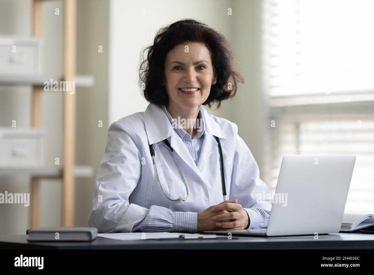 Porträt einer glücklichen Ärztin mittleren Alters in der Klinik. Stockfoto