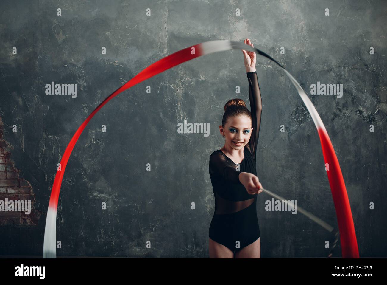 Junge Mädchen professionelle Turnerin Frau rhythmische Gymnastik mit Band im Studio Stockfoto