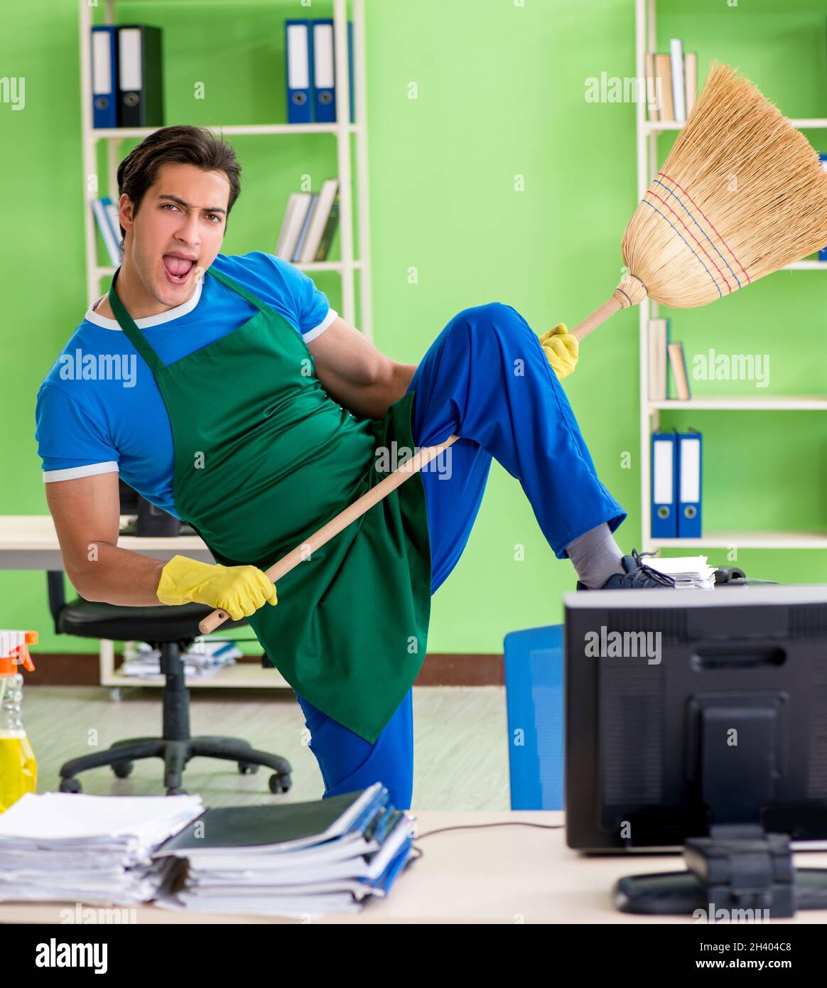 Junge männliche gutaussehenden professionelle Reiniger Reinigung Boden mit Br Stockfoto