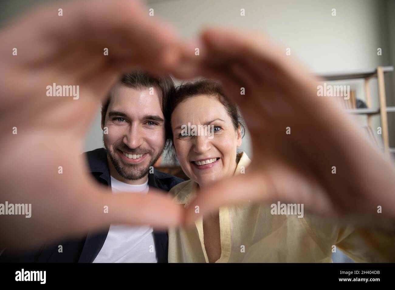 Glückliche zwei Generationen Familie kauen Herz Symbol. Stockfoto