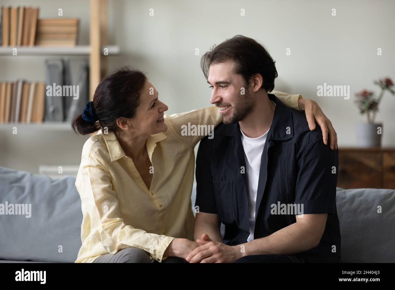 Glückliche Frau im mittleren Alter im Ruhestand im Gespräch mit erwachsenen Sohn. Stockfoto