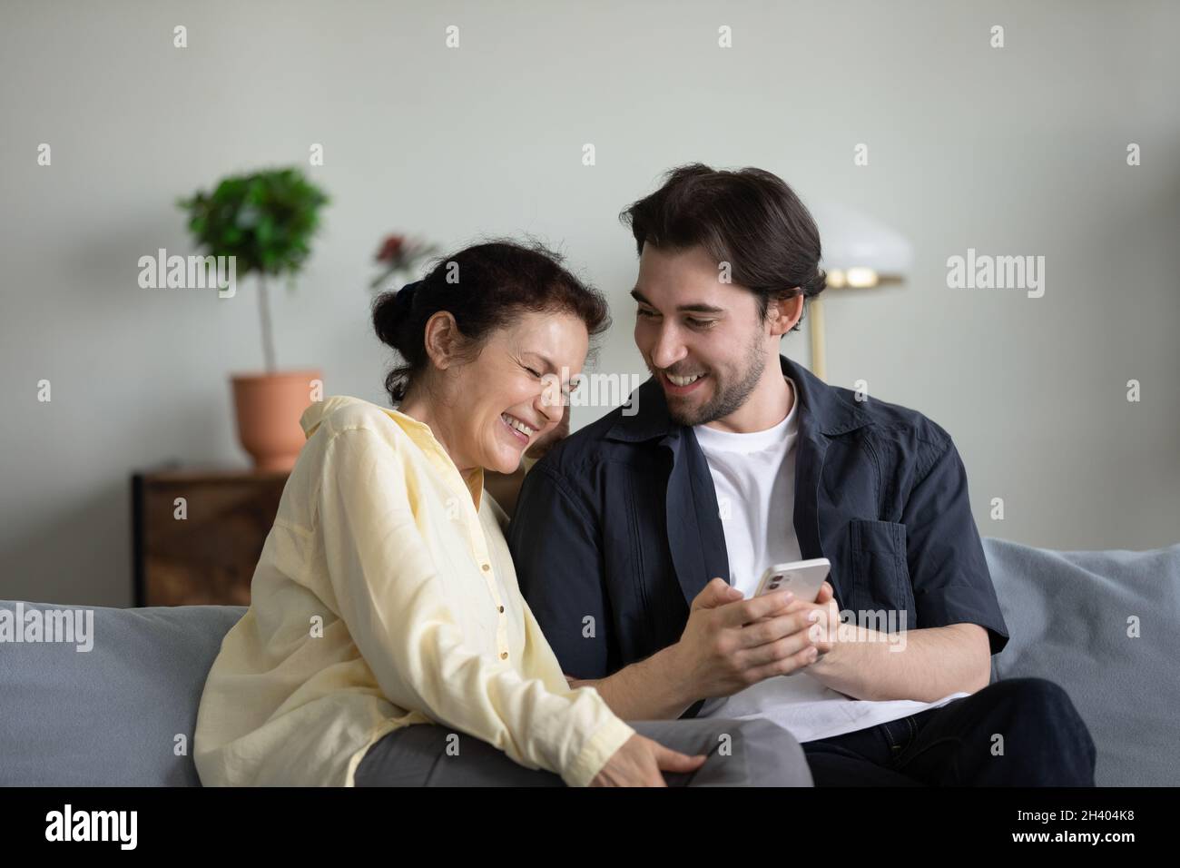 Glückliche zwei Generationen Familie mit Handy zu Hause. Stockfoto