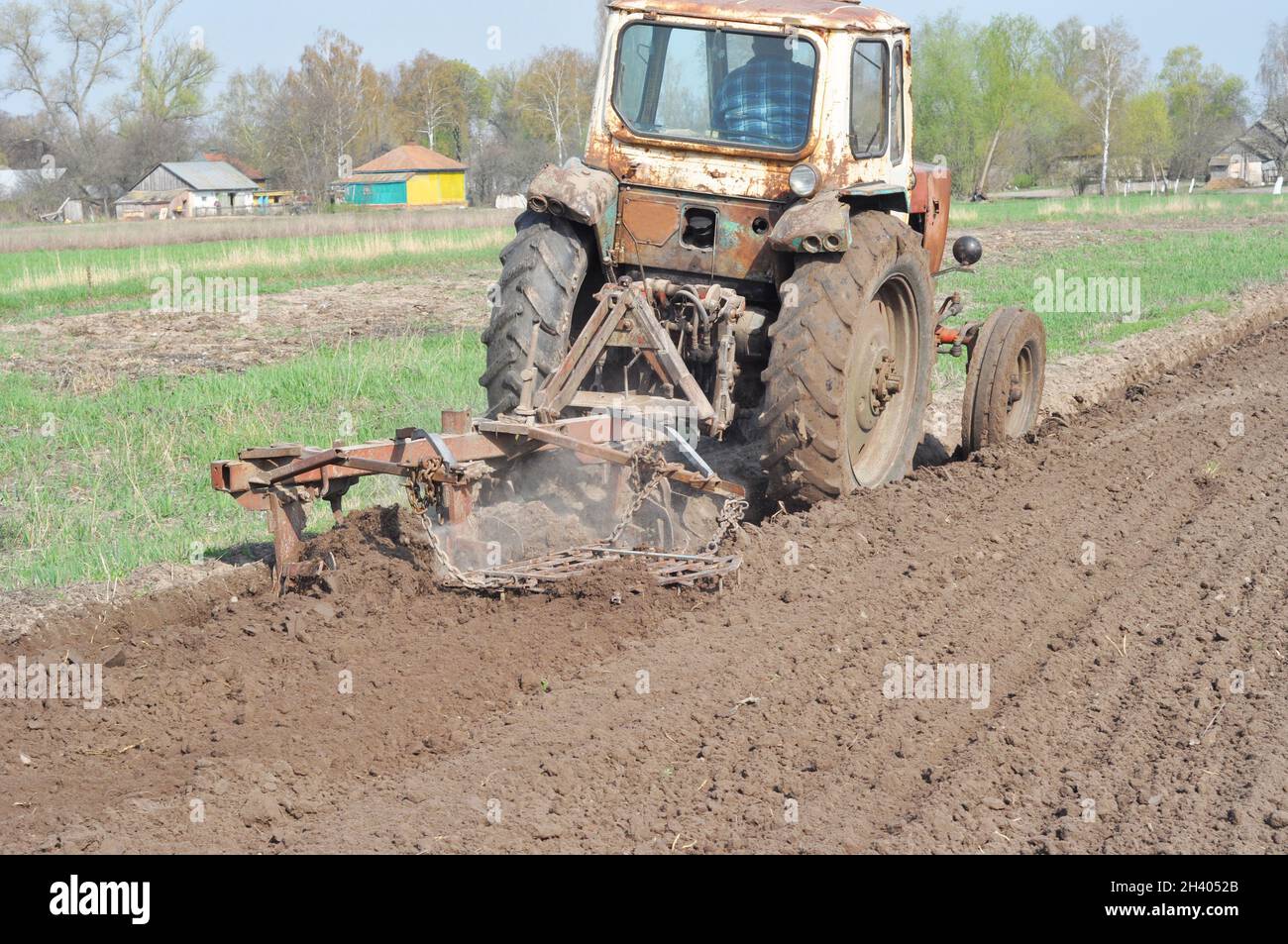 Feld für das Pflügen des Traktors. Ein alter Traktor pflügt auf dem Ackerland. Stockfoto