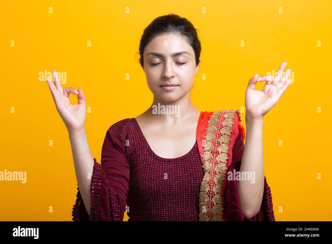 Porträt einer jungen erwachsenen inderin im Sari, die Zen wie mit ok-Zeichen-Mudra-Geste meditiert Stockfoto