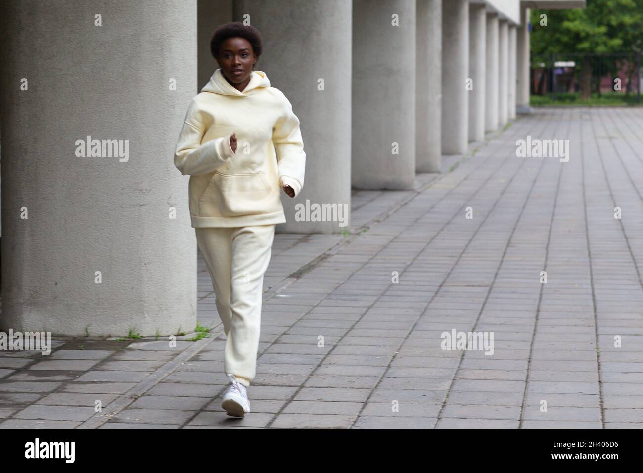 Afroamerikanische Läuferin Frau im Hoodie beim Joggen im Freien Stockfoto