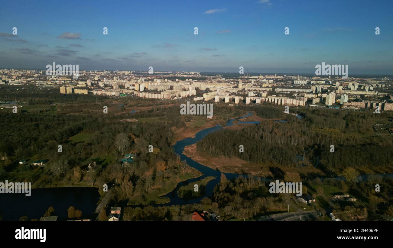 Stadt Herbst Park mit einem Fluss. Fliegen in den Vororten. Am Horizont stehen Hochhäuser. Luftaufnahmen. Stockfoto