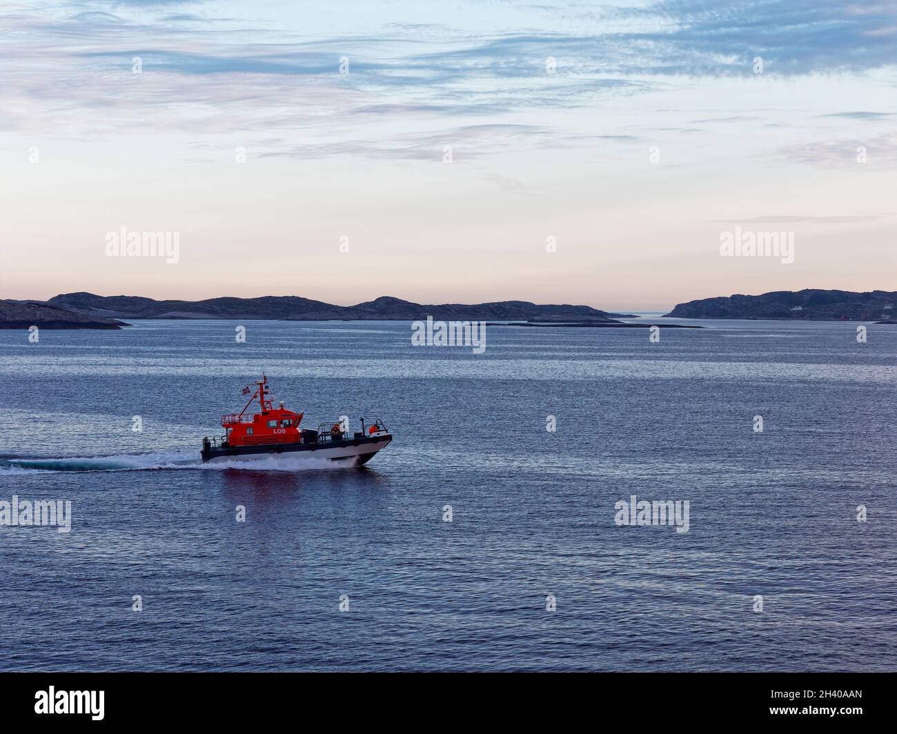 Das Bergen Pilot Boat begleitet ein Schiff durch den Fjord zwischen den vielen kleinen Inseln, die an der norwegischen Küste zu sehen sind. Stockfoto
