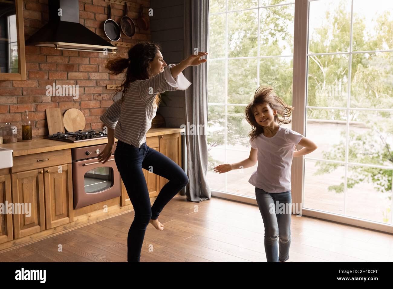Aufgeregt Mutter und Tochter Mädchen tanzen zu Musik in der Küche Stockfoto