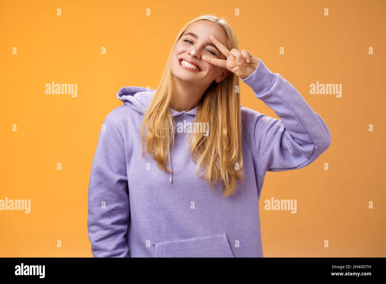 Sorglose optimistische junge süße blonde kaukasische Freundin mit Spaß genießen Sonne perfekt Frühling Wetter winking frech lächeln Stockfoto