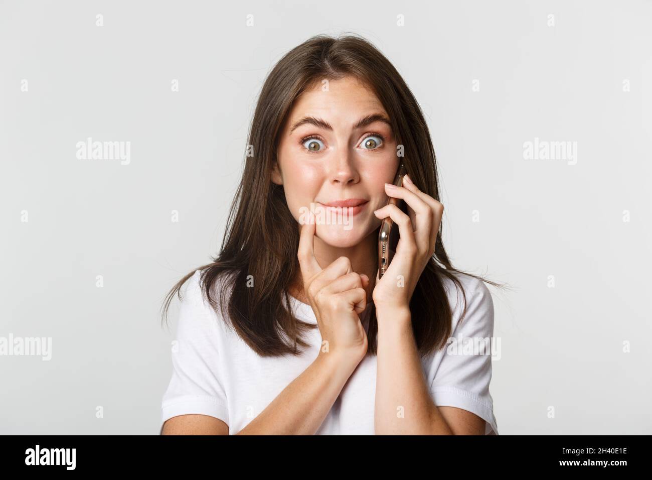 Close-up von fasziniert lächelnd Mädchen im Gespräch auf dem Smartphone mit versucht Ausdruck Stockfoto