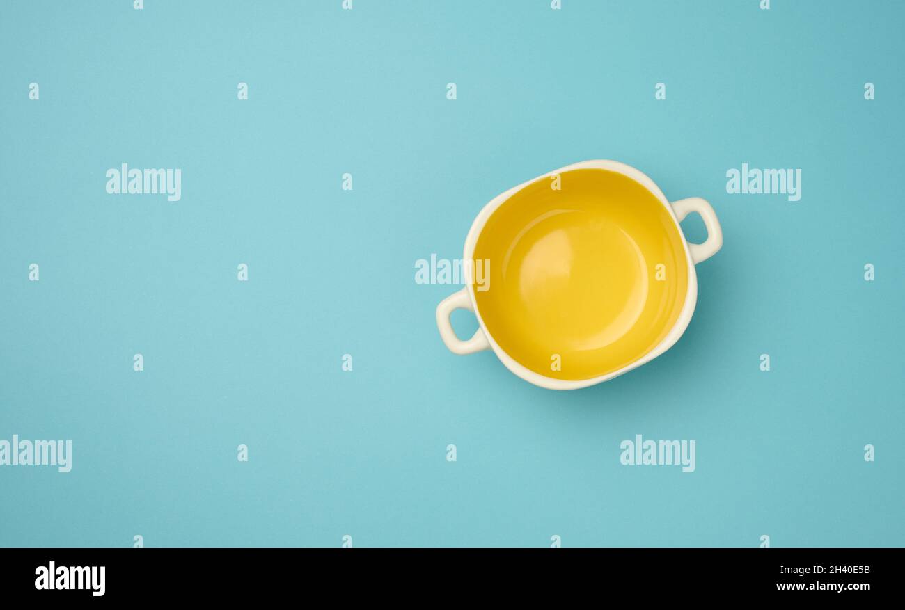 Leere gelbe Suppenteller auf blauem Hintergrund, Draufsicht Stockfoto