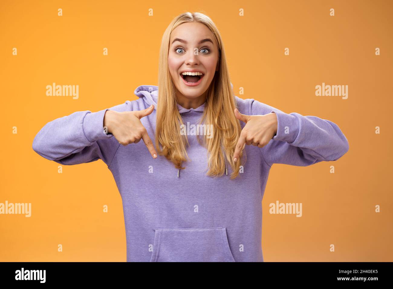 Aufgeregt fasziniert europäischen niedlichen jungen Mädchen blonde Haare lächeln offenen Mund amüsiert erzählen Blick nach unten zeigt nach unten erstaunlich Co Stockfoto