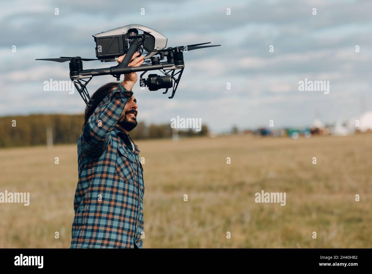Man Pilot hält DJI Inspire 2 Quadcopter Drohne in den Händen auf dem Außenfeld. Stockfoto