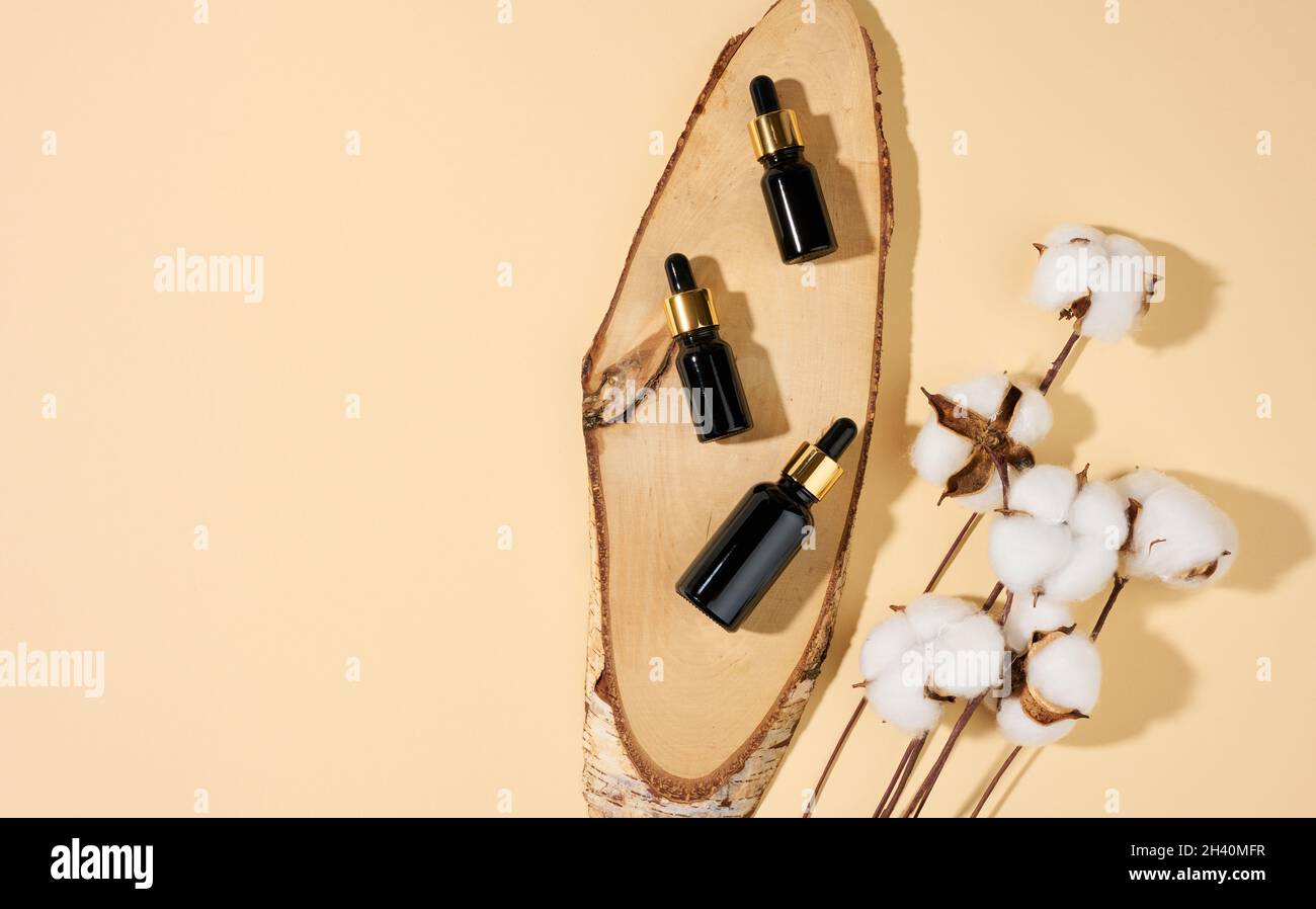 Braune Glasflaschen mit Pipette auf beigem Hintergrund. Kosmetik SPA Branding Mockup, Draufsicht Stockfoto