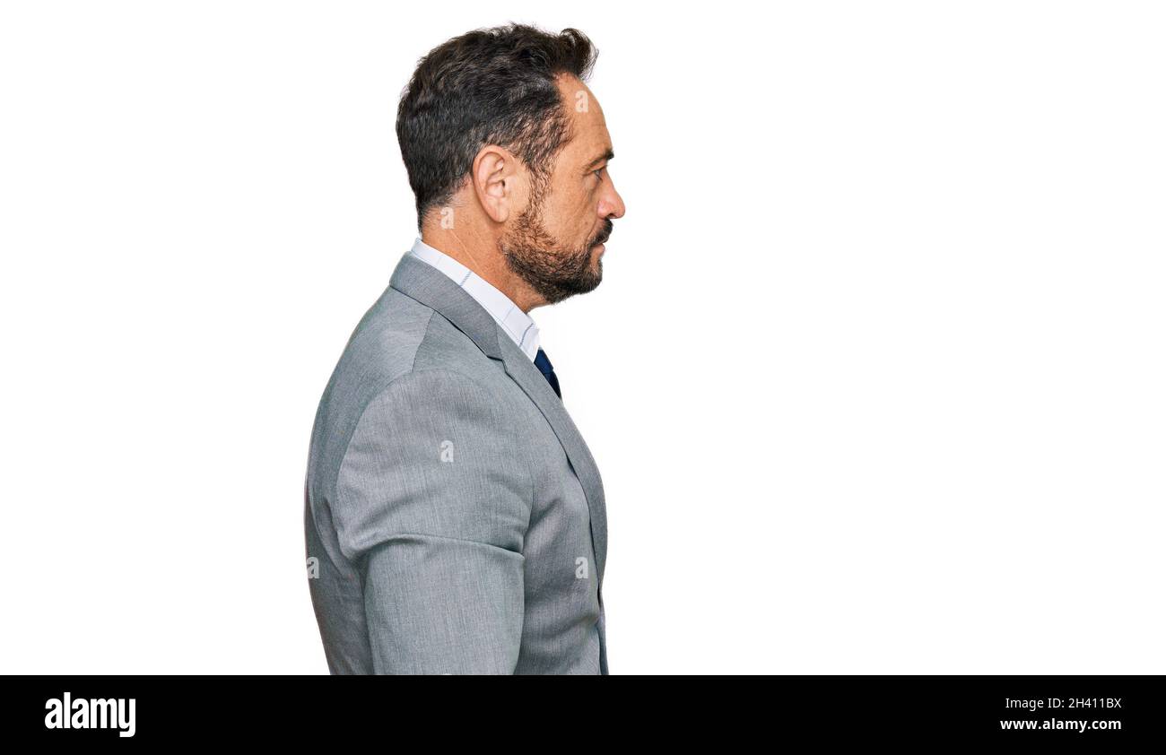Mann mittleren Alters trägt Geschäftskleidung, die zur Seite schaut, relax Profil Pose mit natürlichem Gesicht und selbstbewusstes Lächeln. Stockfoto