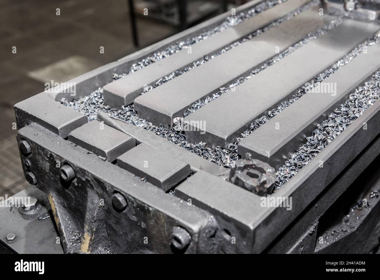 Nahaufnahme eines Teils der horizontalen Fräsmaschinen und Werkzeuge mit Eisenabfällen nach der Metallbearbeitung in der Werkstatt der Industrieanlage. Stockfoto