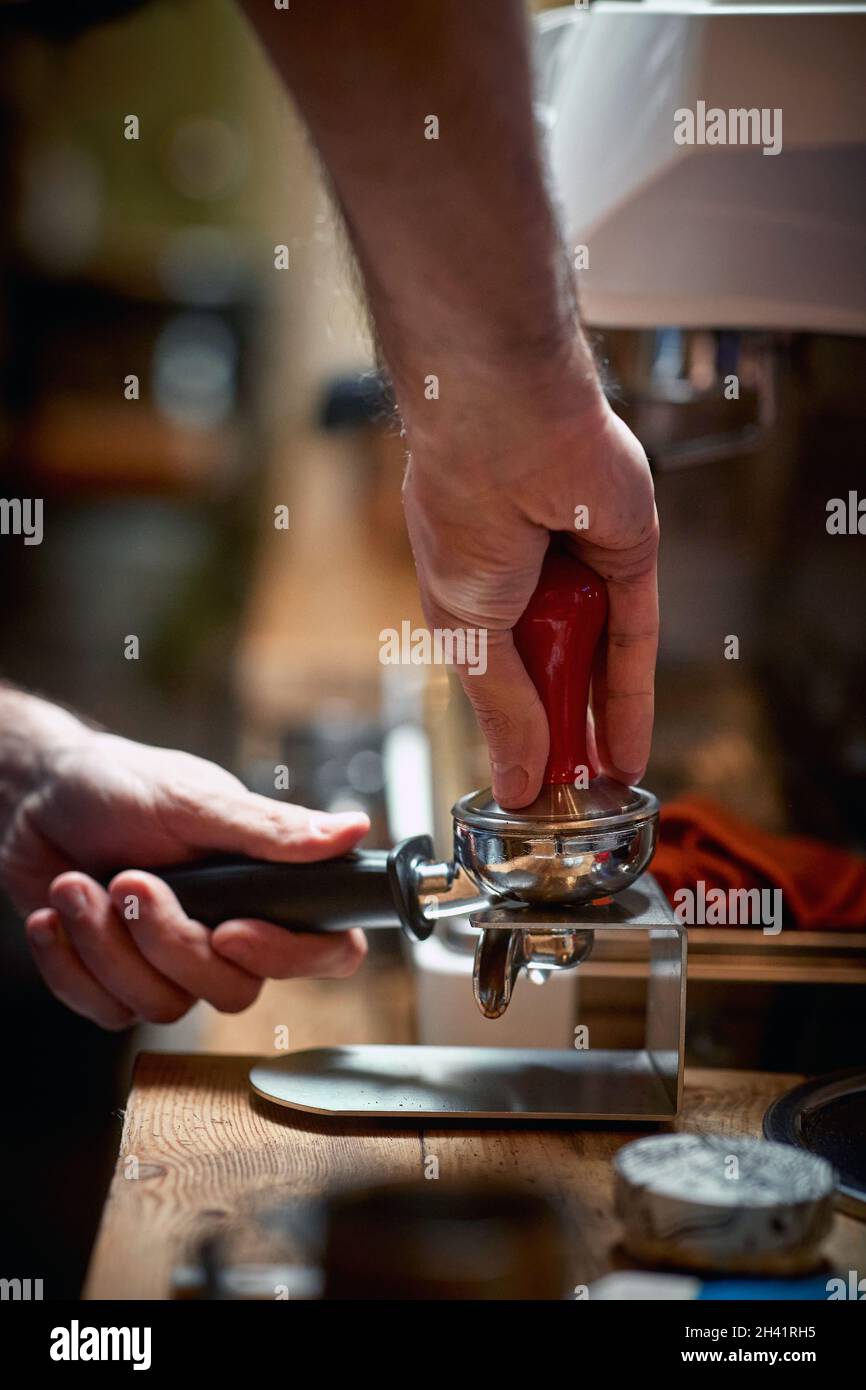 Ein Barkeeper bereitet hinter der Bar einen duftenden und aromatischen Espresso zu. Kaffee, Getränke, Bar Stockfoto