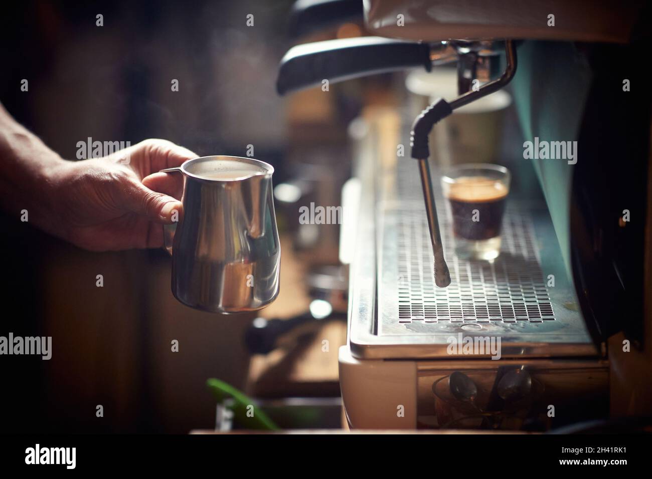 Ein Barkeeper verwendet einen Espresso-Apparat, um ein aromatisches Getränk zuzubereiten. Kaffee, Getränke, Bar Stockfoto