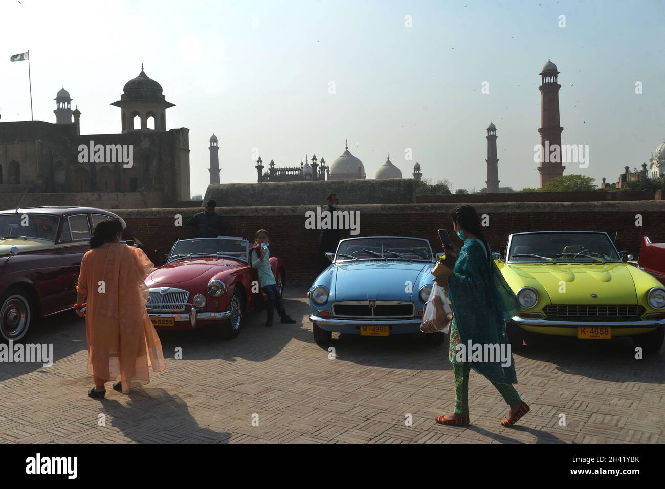 Pakistanische Bürger nehmen die Autoshows der Oldtimer-Rallye auf, die von der Walled City Authority Lahore (WCLA) am 30. Oktober 2021 im historischen Fort Lahore in Lahore, Pakistan, organisiert wurde. Mindestens 14 einzigartige Fahrzeuge von 1935 bis 1965 Modellen, darunter Mercedes & Beatle Ford, nahmen an der Rallye Teil. (Foto von Rana Sajid Hussain / Pacific Press/Sipa USA) Stockfoto
